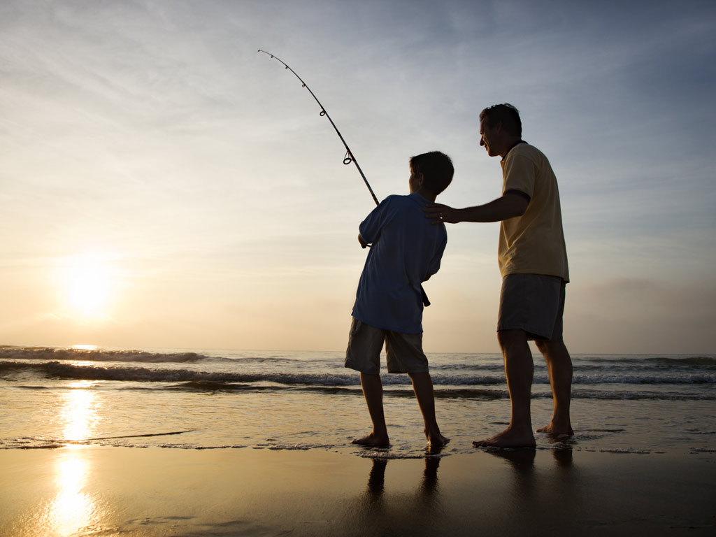 A-father-and-son-surf-fishing-at-sunset.